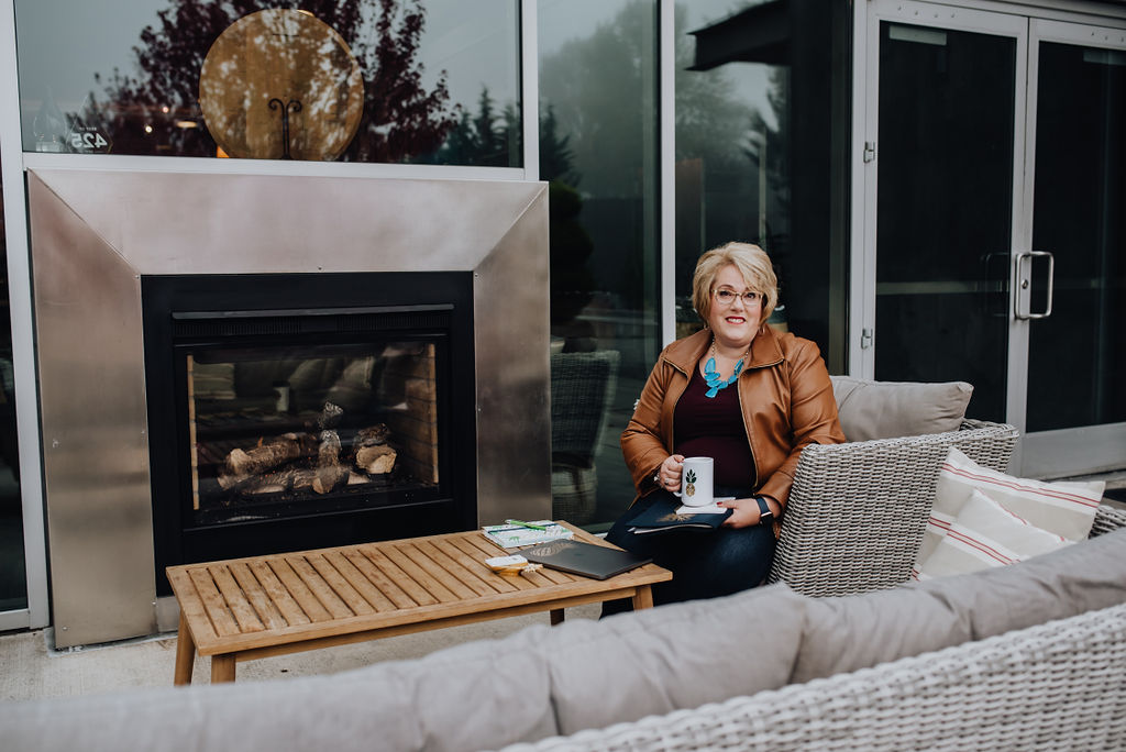 blonde hair women sitting next to outdoor fireplace